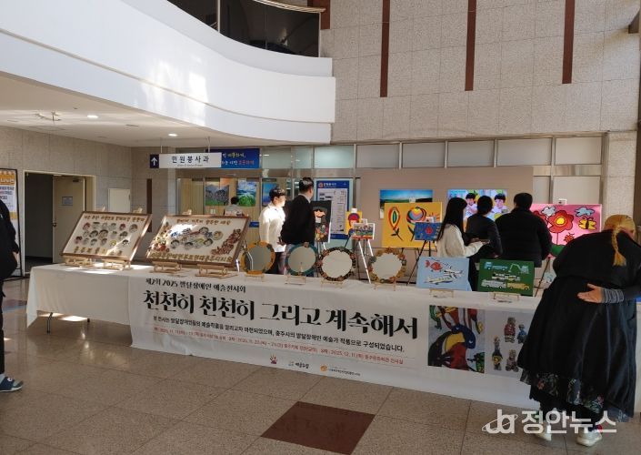 충주시청서 제2회 발달장애인 예술전시회 개최(시민들이 전시회 작품을 보고 있다)