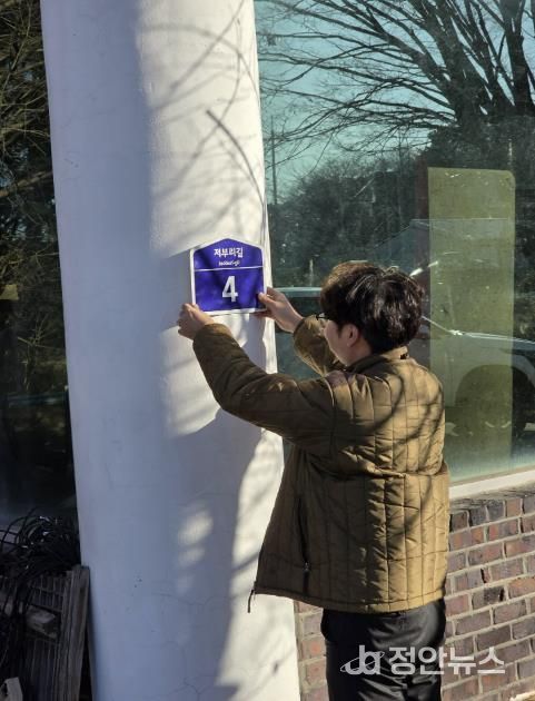 군 행복민원과 직원이 도로명주소 건물번호를 직접 배달하며 부착하고 있다.