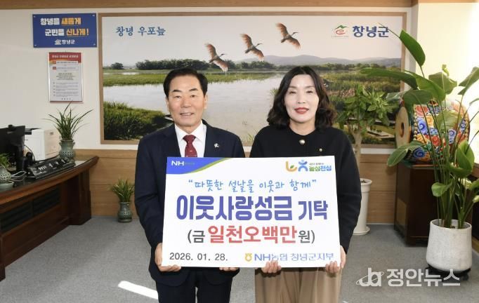 유동경 지부장이 설맞이 이웃사랑성금을 기탁하며 성낙인 군수와 기념촬영을 하고 있다.