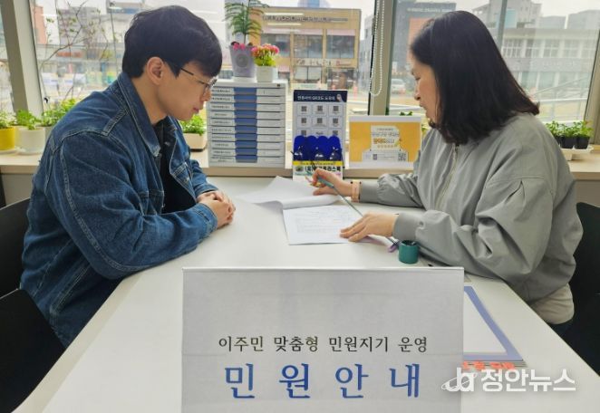 광산구 이주민 맞춤형 민원지기가 구청 1층 민원실에서 민원인의 서류 작성을 돕고 있다.