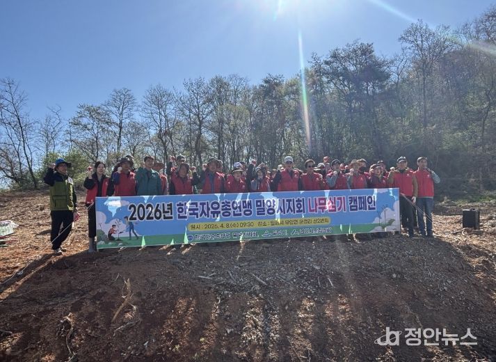 한국자유총연맹 밀양시지회 회원들이 나무심기 행사를 개최하고 기념 촬영을 하고 있다.